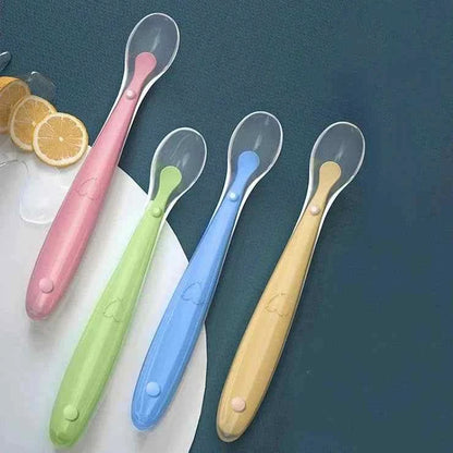 Silicone Baby Feeding Spoons in pink, green, blue and yellow, with clear oval spoon heads and soft silicone handles.
