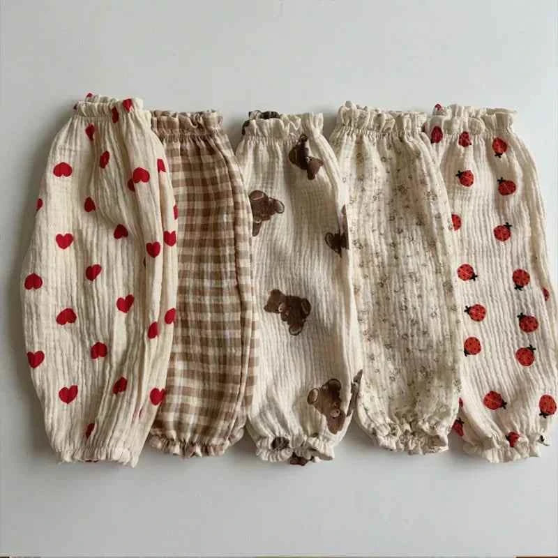 Soft Print Baby cotton-look pants in cream with red hearts, brown gingham, bear motifs, tiny floral print and ladybugs, elastic cuffs.