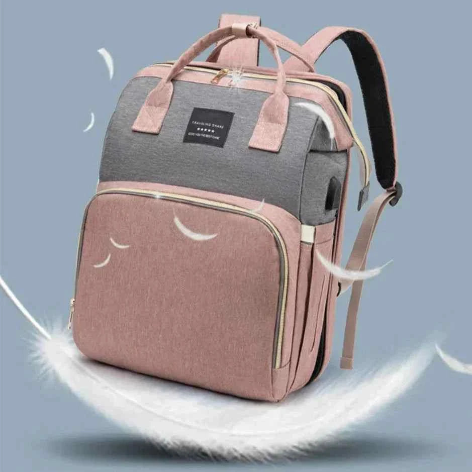 Ultimate Baby Travel Bag in pink and grey fabric, with a spacious zippered front pocket, top handles, and shoulder straps.