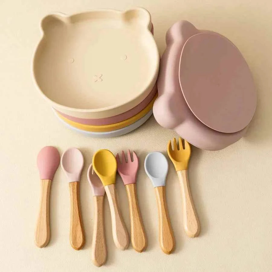 Silicone Suction Baby Feeding Set with pastel silicone bear-face bowl, suction plate and wooden-handled utensils.
